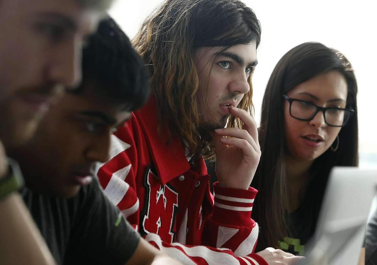 Ruby Nealon (center) verifies a possible bug he discovered for Airbnb with Keziah Plattner (center right) at a hackathon in San Francisco, Calif. on Saturday, Feb. 11, 2017. Hackers of all abilities were invited by HackerOne to find vulnerabilities and bugs in systems operated by Shopify and Airbnb.