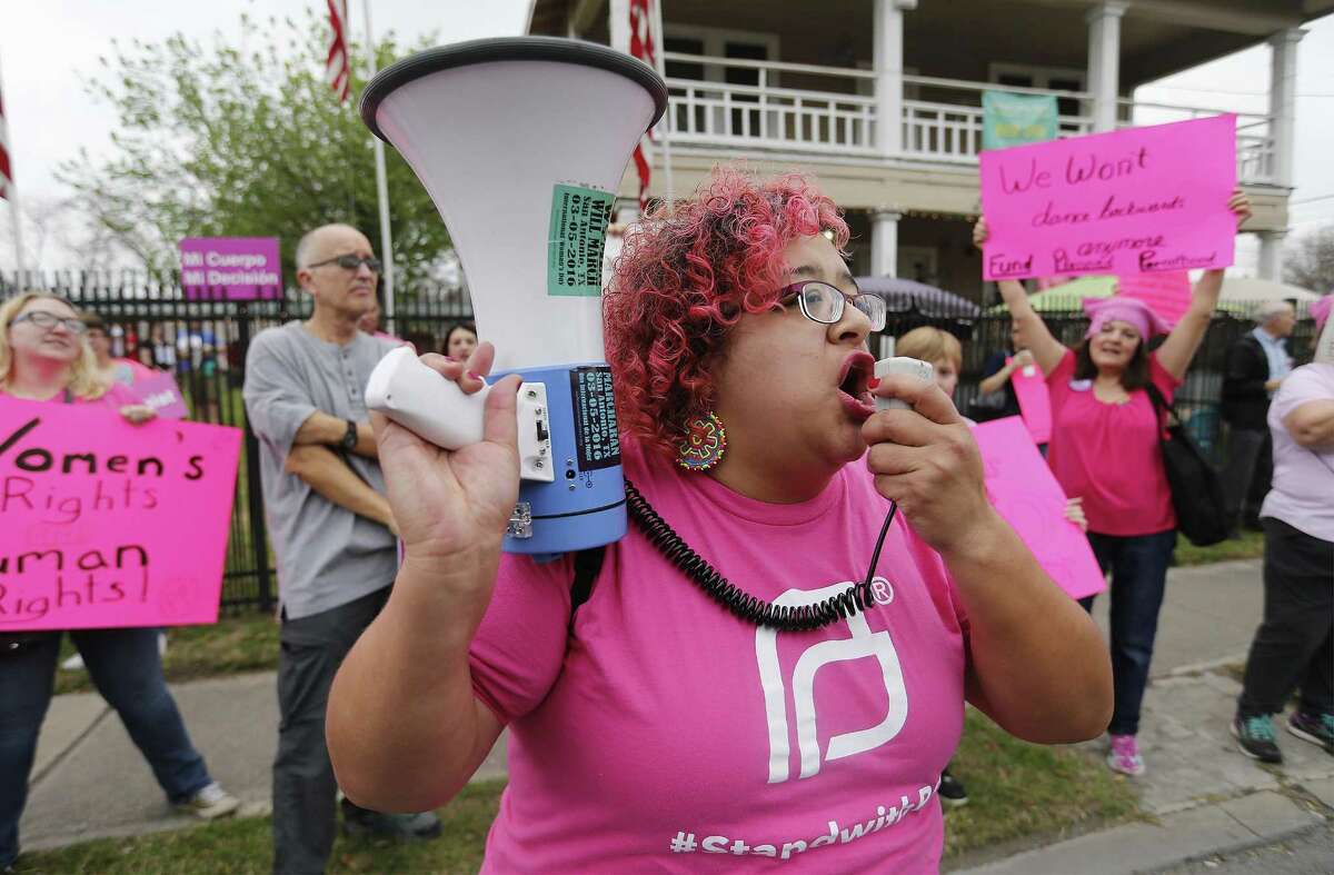 Barbie Hurtado rallies supporters of Planned Parenthood on a sidewalk along West Commerce Street on Saturday, Feb. 11, 2017. Following the Women's March in Washington last month, three San Antonio women organized a rally on Saturday with about 200 supporters on the city's Westside to rally in support of the organization. Supporters cited women's rights to govern their own bodies amongst some of the key reasons for keeping the non-profit organization that provides health services for women operational and funded. People at the rally lined Commerce Street and waved signs in support of Planned Parenthood. Speeches from concerned citizens were heard as supporters cheered and applauded at Sabinas Coffee Shop. (Kin Man Hui/San Antonio Express-News)