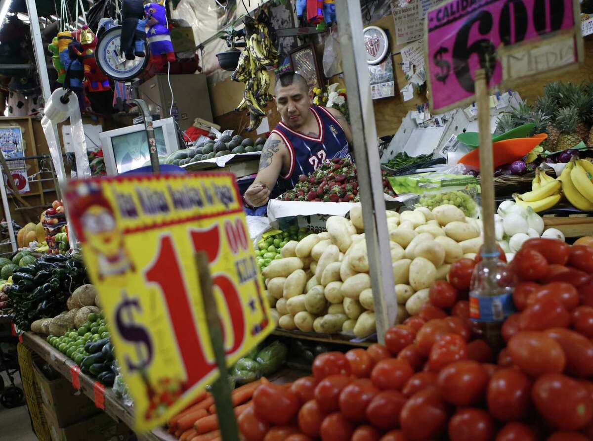 Vendor Luis Alberto Bautista arranges strawberries as he lays out fresh produce at the start of the day, in his vegetable stand in Mercado Medellin, in Mexico City, Thursday, Feb. 2, 2017. Mexico is the worldís leading exporter of refrigerators and flat-screen TVs. Cars and trucks such as the Ram 1500 crew cab, Ford Fiesta and Chevrolet Trax fill U.S. dealer lots. Mexican berries, vegetables and beef born south of the border abound at American supermarkets. (AP Photo/Rebecca Blackwell)