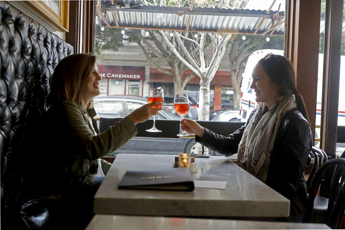 San Francisco residents Katie Hayes, left, and Natalie Williamson, right, cheers their champagne glasses at Riddler, a champagne bar in San Francisco, Calif. on Feb. 10, 2017.