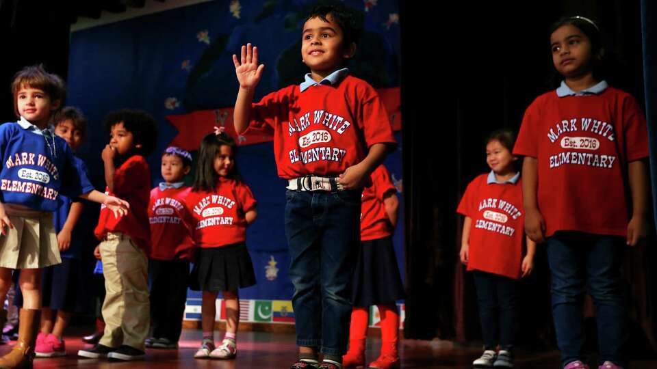 Pre-K student Shounak Tambi waves to the crowd before performing in English and French during the grand opening of Mark White Elementary on Monday, Dec. 12, 2016, in Houston. (Annie Mulligan / Freelance)