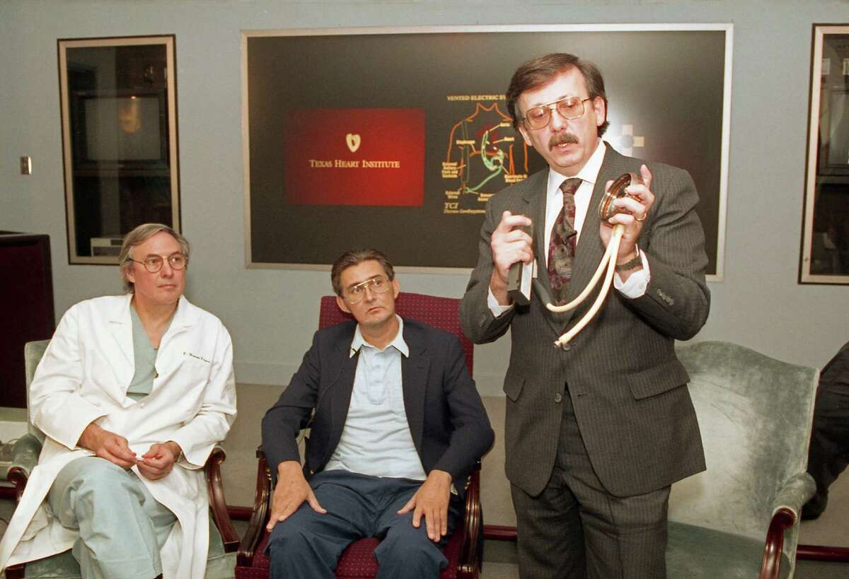 Heart surgeon Dr. Bud Frazier and patient Mike Templeton watch as Victor Poirier, developer of the HeartMate, explains the portable, battery-powered ventricular assist device to the media on Oct. 1, 1991, at the Texas Heart Institute.