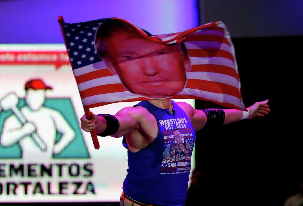 Wrestler Sam Polinsky, aka Sam Adonis, takes the ring Sunday ﻿in Mexico City waving an American flag emblazoned with a photo of ﻿Donald Trump﻿.