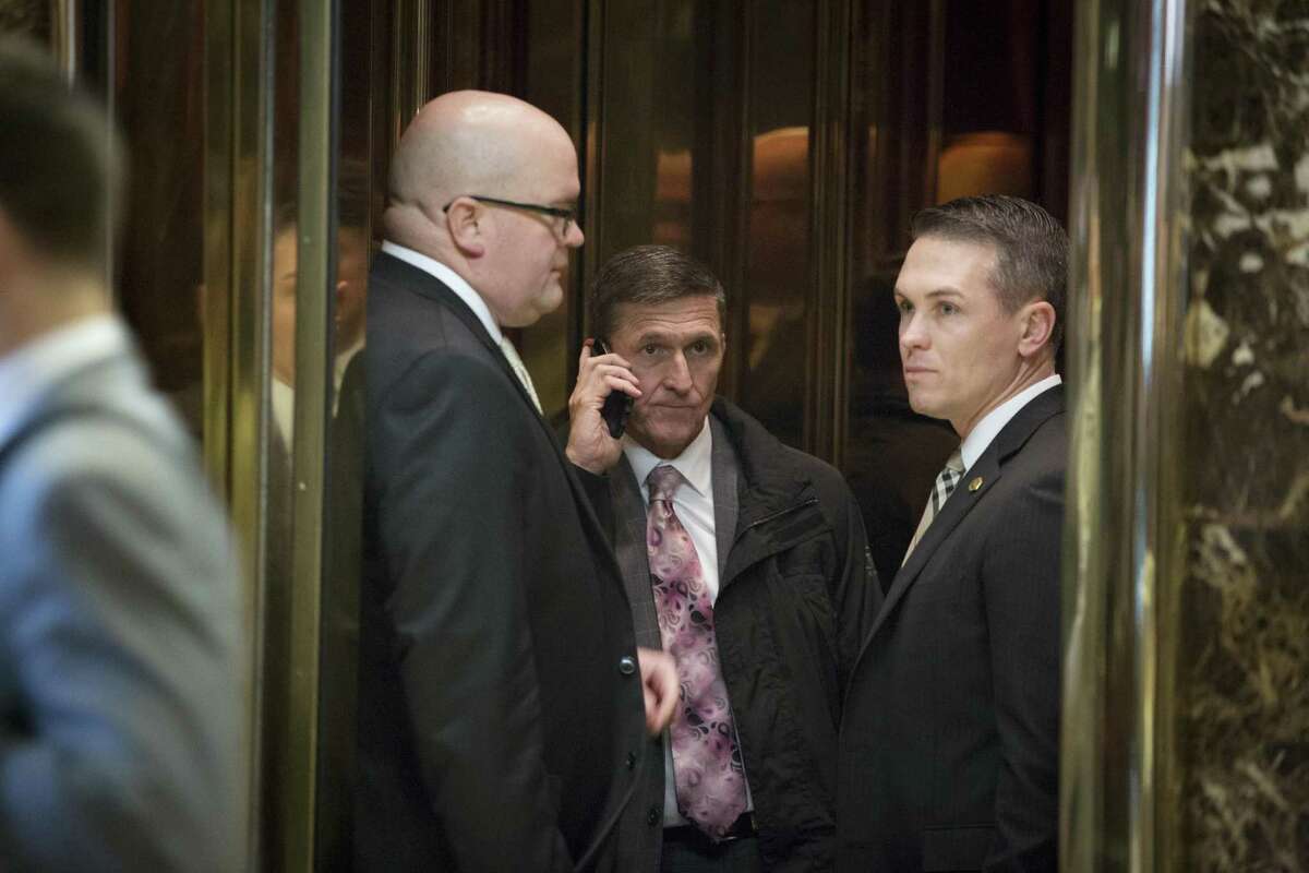 FILE -- Michael Flynn, center, who on Feb. 13, 2017 resigned his position as President Trump's national security adviser, on an elevator in the lobby of Trump Tower on Fifth Avenue in New York, Jan. 12, 2017. The resignation is fueling the notion by some Russian lawmakers that Russophobia is again stalking the corridors of power in Washington. (Kevin Hagen/The New York Times)