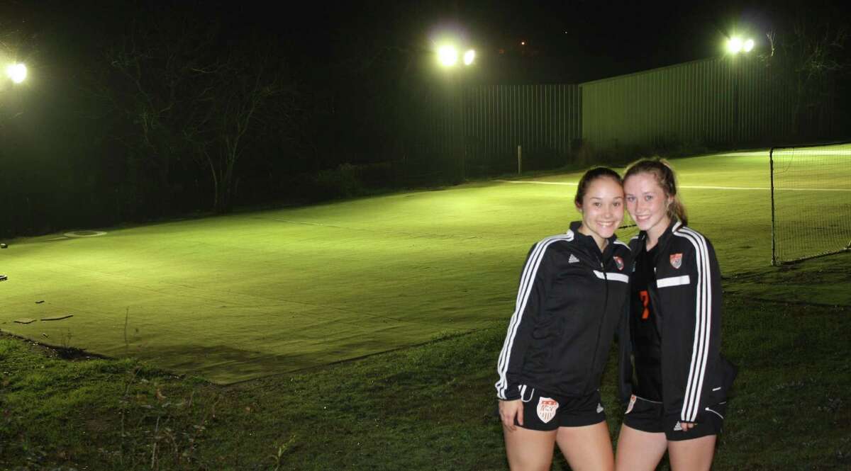 Medina Valley High School soccer players — and sisters — Mackenzie (left) and Audra Clark pose on Feb. 13, 2017, near the lighted field their father, Bobby, built for them in a farm field in Castroville.