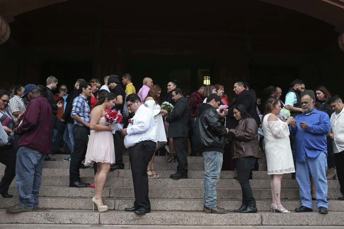 Couples exchanges rings during weddings in front of the Bexar County Courthouse on Valentine's Day, Feb. 14, 2017. Around 26 couples braved the cold winds to marry during the ceremony conducted by Bexar County Clerk Gerard Rickhoff.