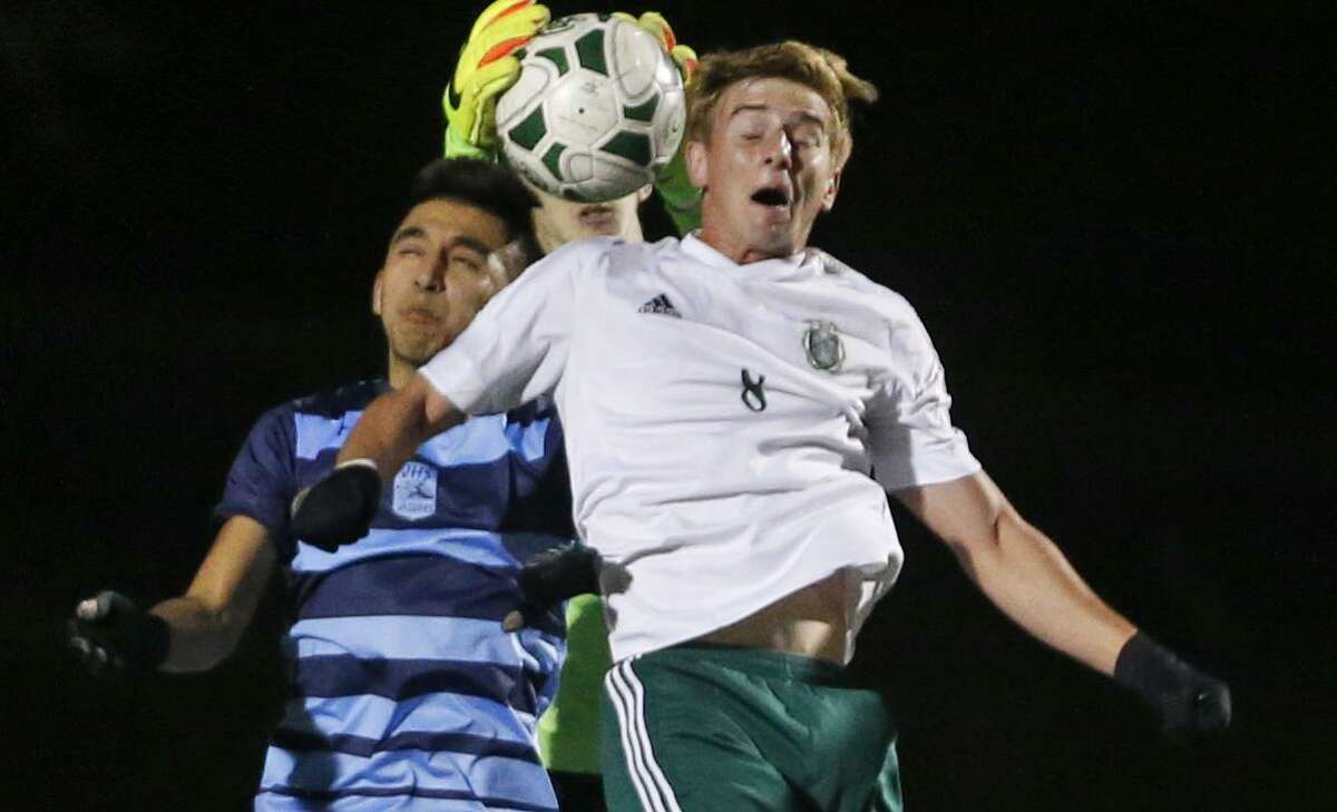 Reagan’s Justin Sukow (right) is unable to score as Johnson goalkeeper Andrew Mcllvoy intercepts the ball during a District 26-6A high school soccer game on Feb. 14, 2017.