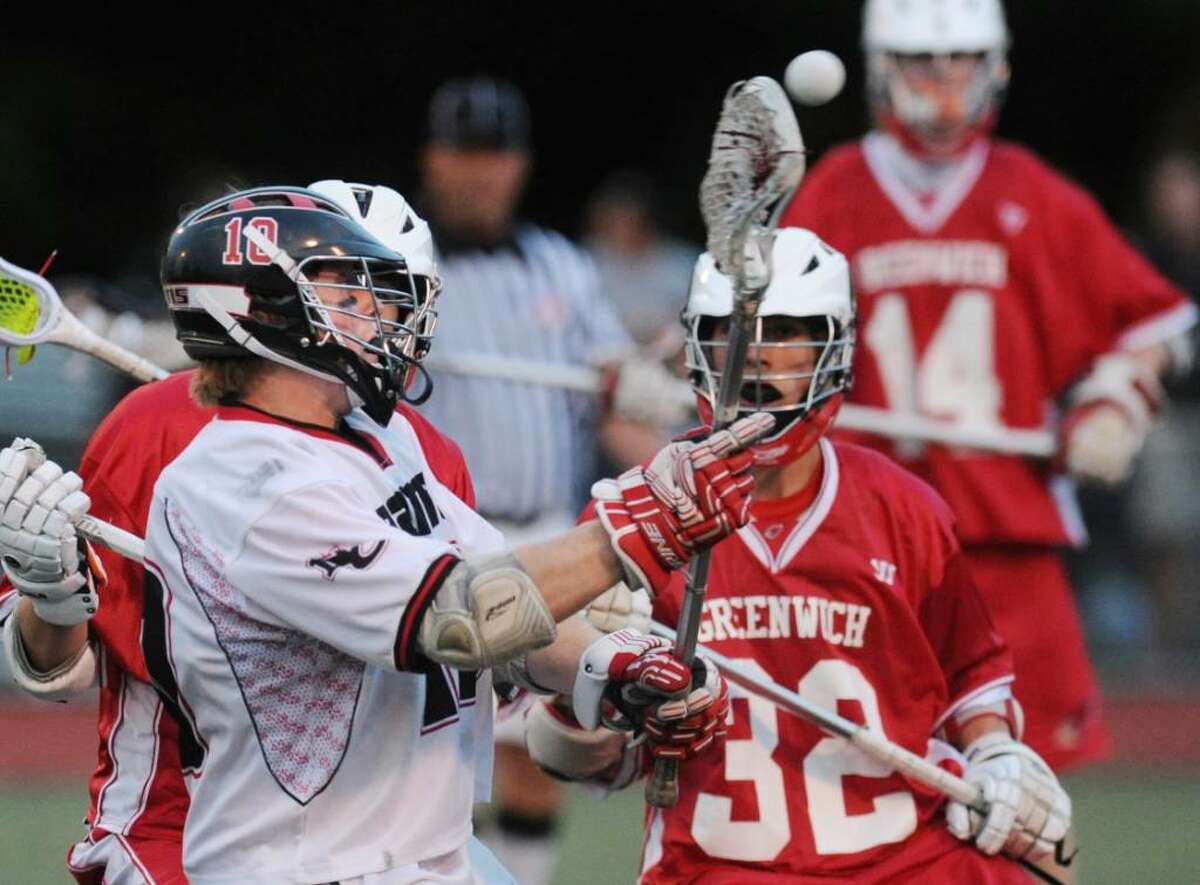 Henry Richardson of New Canaan, # 11, passes during 2nd quarter action of the FCIAC Lacrosee Championship at Brien McMahon High School, Norwalk, Friday evening, May 28, 2010. Covering on the [lay is Kevin Brockman, # 32 of GHS, right.
