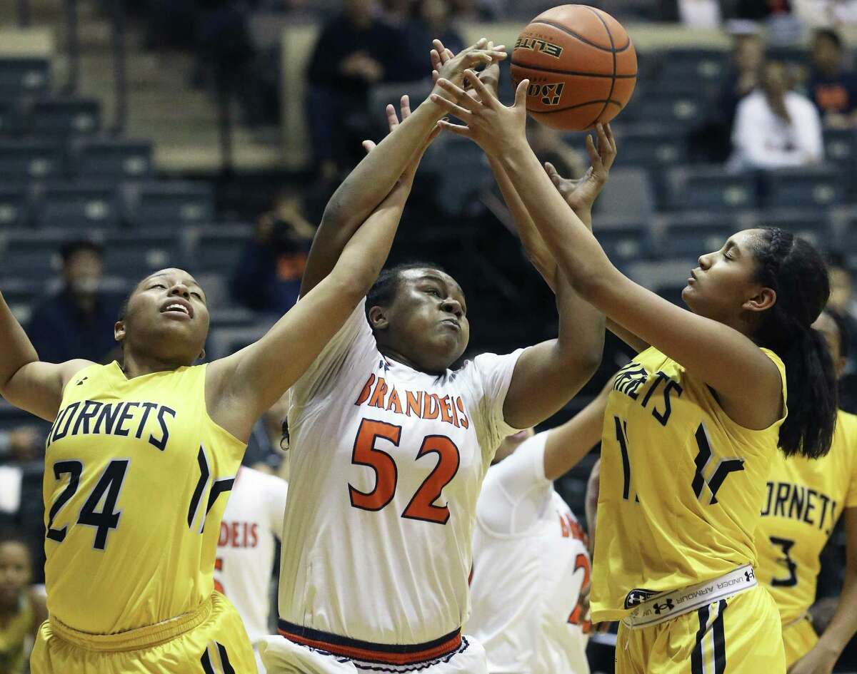 Brandeis’ Breauna Delon battles East Central’s Brittany Rodgers (left) and Ryan Gonzalez in their first-round playoff.