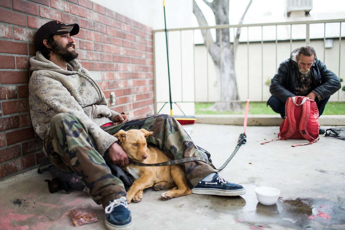 Matt Perry, left, who lives homeless in Oroville, continues to stay at the evacuation center at the Butte County Fairgrounds, with his dog, Honey, in Chico, California on February 15, 2017.