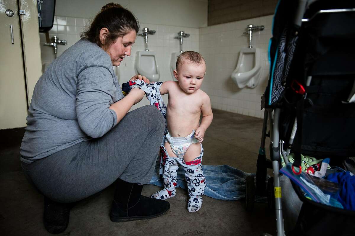 Krystal Morrison dresses her 14-month-old son, Albert, Jr. after his first shower in three days at the evacuation center at the Butte County Fairgrounds in Chico, California on February 15, 2017. The Morrisons live in a halfway house for substance abuse in Oroville.
