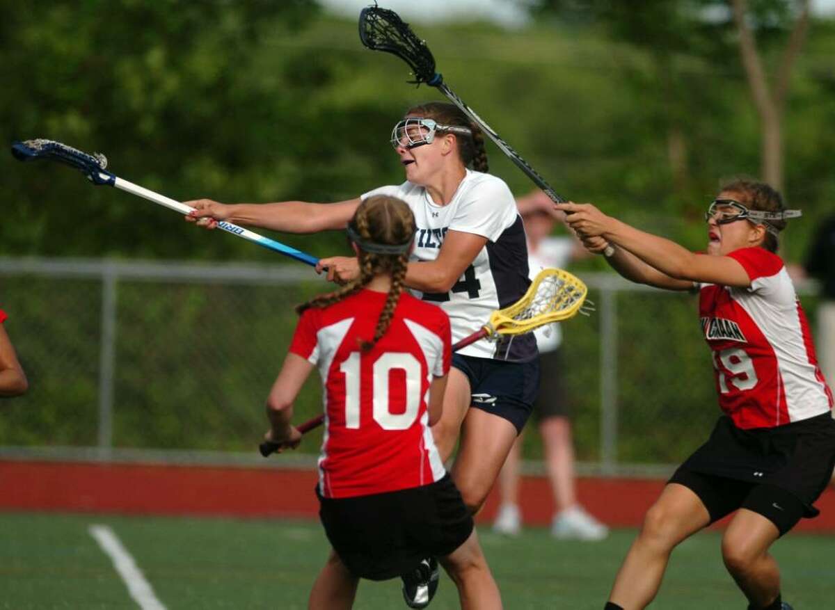 Wilton's Casey Pearsall shoots and scores as New Canaan's Sarah Mannelly, left, and Hannah Femia defend during the Girls Lacrosse FCIAC Championship game Friday May 28, 2010 at Brien McMahon High School in Norwalk.