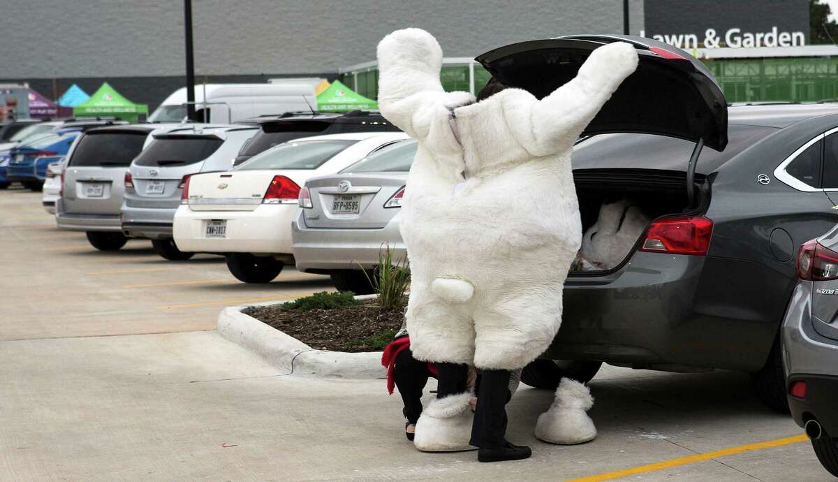Laura Galvan puts on a polar bear costume for the opening of the new Wal-Mart on Wednesday, Feb. 15, 2017, in Tomball.