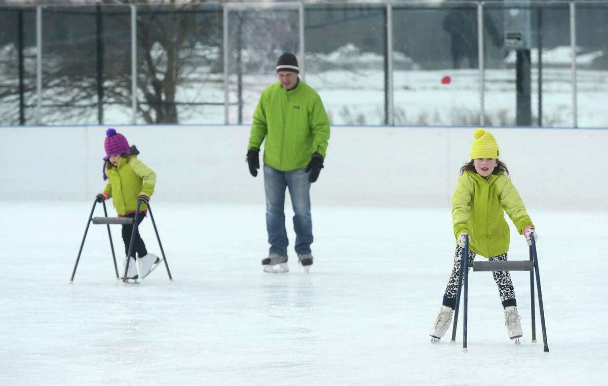 John Early watches his daughters, Georgina and Allegra Early, 5 and 7, learn how to skate at the PAL Rink at Longshore Saturday, February 11, 2017, in Westport, Conn.