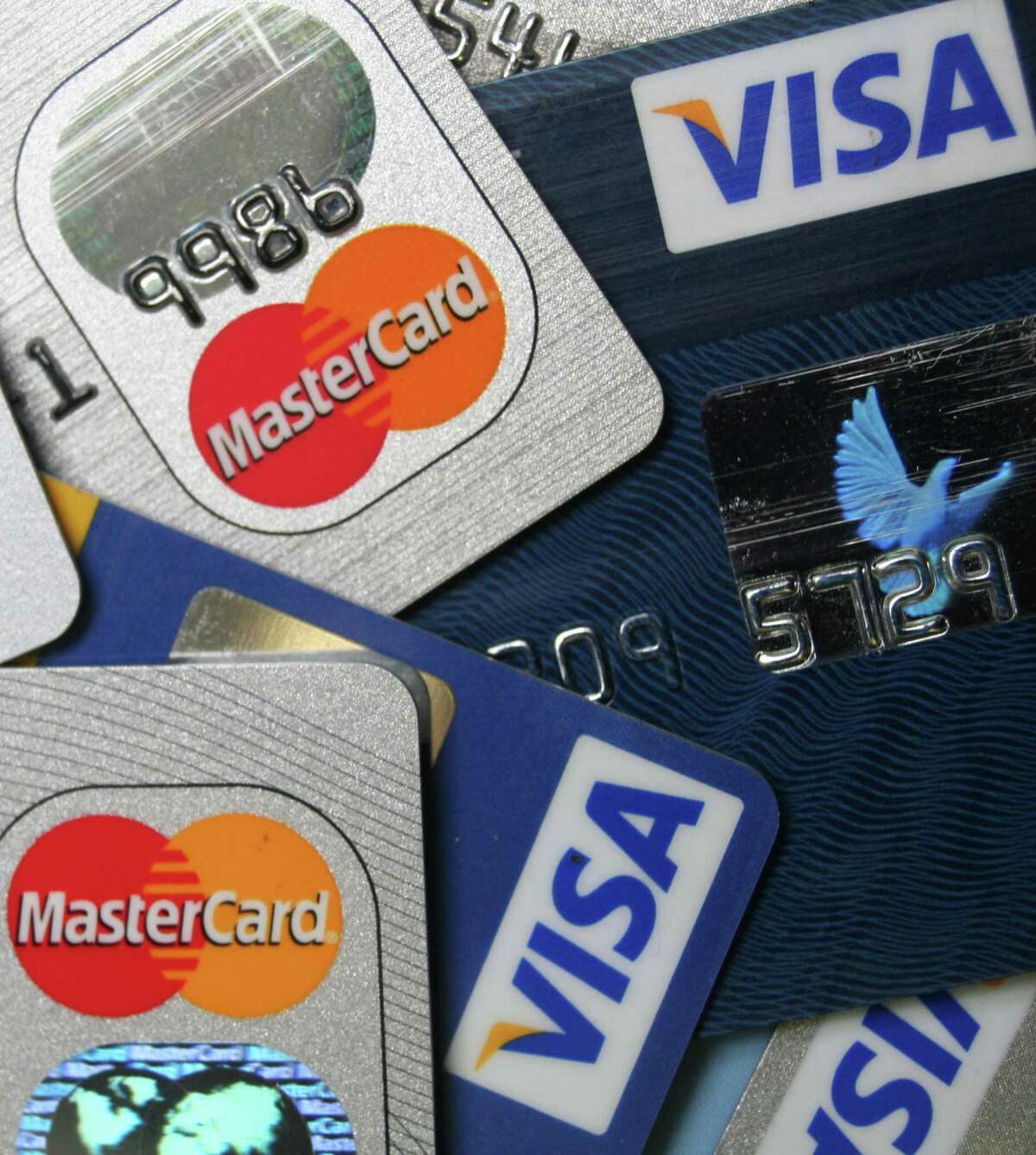 This file photo taken Nov. 18, 2009, shows a pile of MasterCard and VISA credit cards in Frankfurt, Germany. Heads are still spinning over credit card bills and charges. A law that went into effect in February 2010, requires banks to provide numerous consumer protections, including clearer monthly statements. Yet confusion about some practices remains widespread. (AP Photo/Jochen Krause, File)