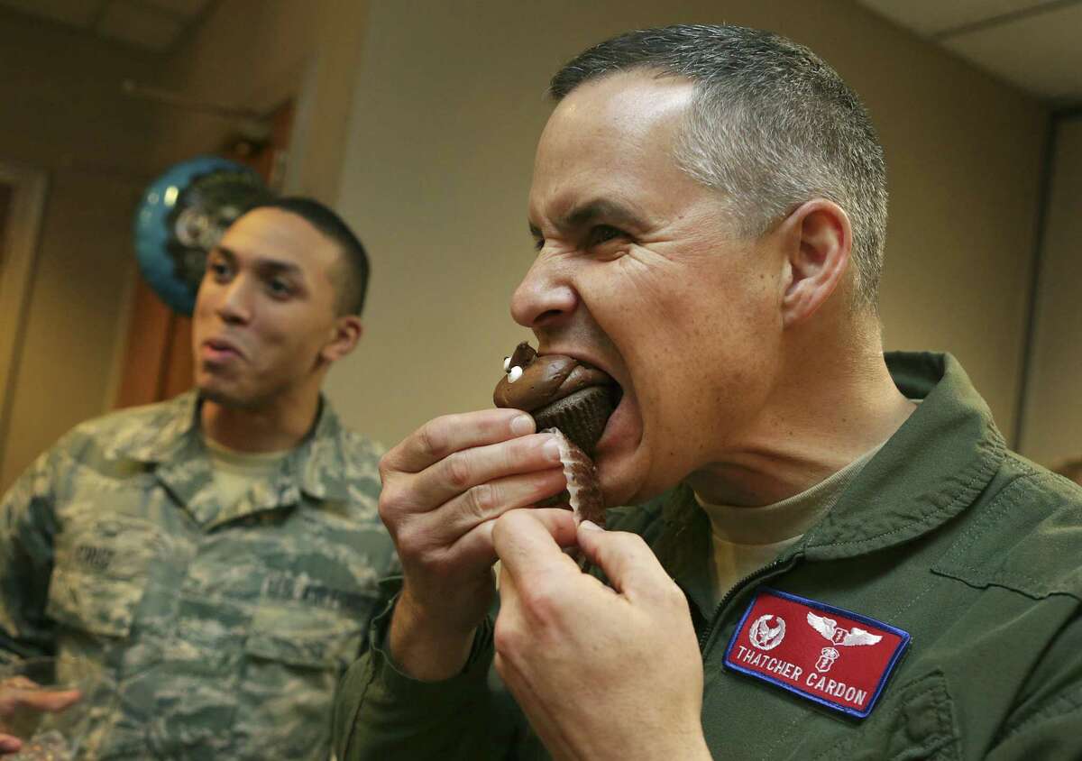 Col. Thatcher Cardon, inventor of a new adaptable hygiene spacesuit system, sinks his teeth into a poop-emoji cupcake at a party celebrating his $15,000 cash prize at Club XL at Laughlin AFB.