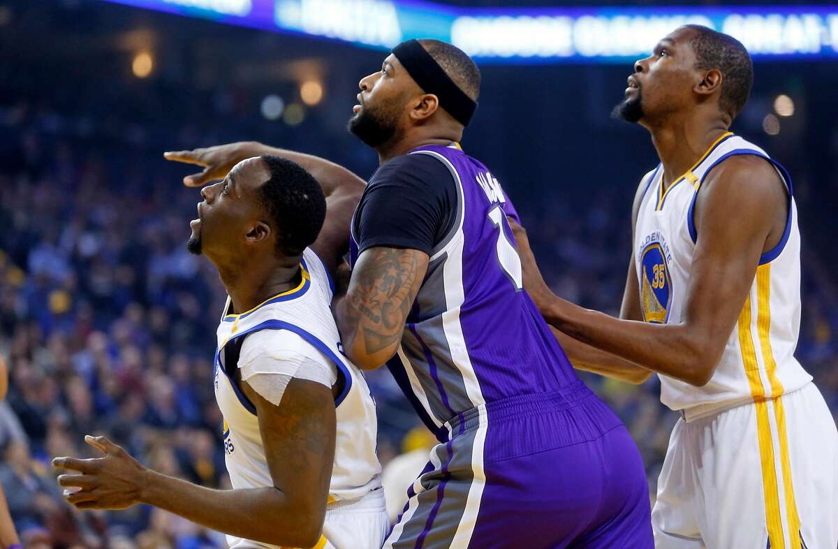 Golden State Warriors' Draymond Green and Kevin Durant box out Sacramento Kings' DeMarcus Cousins in 1st quarter during NBA game at Oracle Arena in Oakalnd, Calif., on Wednesday, February 15, 2017.