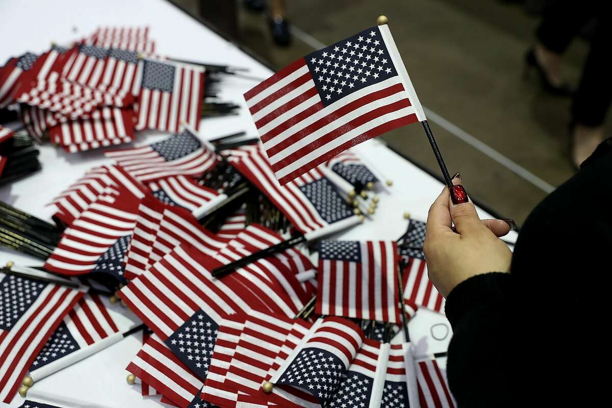 LOS ANGELES, CA - FEBRUARY 15: A workers passes out American flags during a naturalization ceremony held by U.S. Citizenship and Immigration Services at the Los Angeles Convention Center on February 15, 2017 in Los Angeles, California. 6,700 immigrants became U.S. citizens during two naturalization ceremonies held at the Los Angeles Convention Center. (Photo by Justin Sullivan/Getty Images)