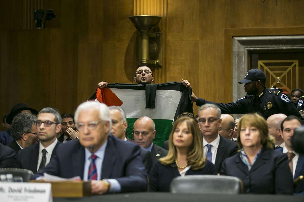 A protester holding a Palestinian flag disrupts a Senate Foreign Relations Committee confirmation hearing for David Friedman, the nominee to serve as ambassador to Israel, on Capitol Hill in Washington, Feb. 16, 2017. Friedman on Thursday spoke broadly of regretting sharp comments made about American Jews during the presidential campaign, promising to be �respectful and measured� if confirmed. (Al Drago/The New York Times)