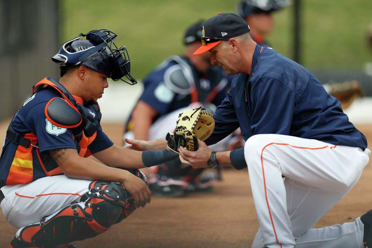 Houston Astros catching coordinator Mark Bailey adjusts Houston Astros catcher Juan Centeno's glove during spring training at The Ballpark of the Palm Beaches, in West Palm Beach, Florida, Thursday, February 16, 2017.