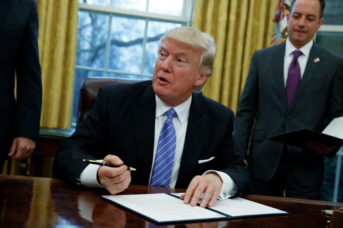 FILE - In this Monday, Jan. 23, 2017, file photo, President Donald Trump signs an executive order to withdraw the U.S. from the Trans-Pacific Partnership trade pact agreed to under the Obama administration, in the Oval Office of the White House in Washington. Less than a month into his presidency, Donald Trump is already dismantling seven decades of American policy by pulling back from established trade agreements, such as the TPP, and questioning longstanding global alliances. (AP Photo/Evan Vucci, File) ORG XMIT: NYAG401