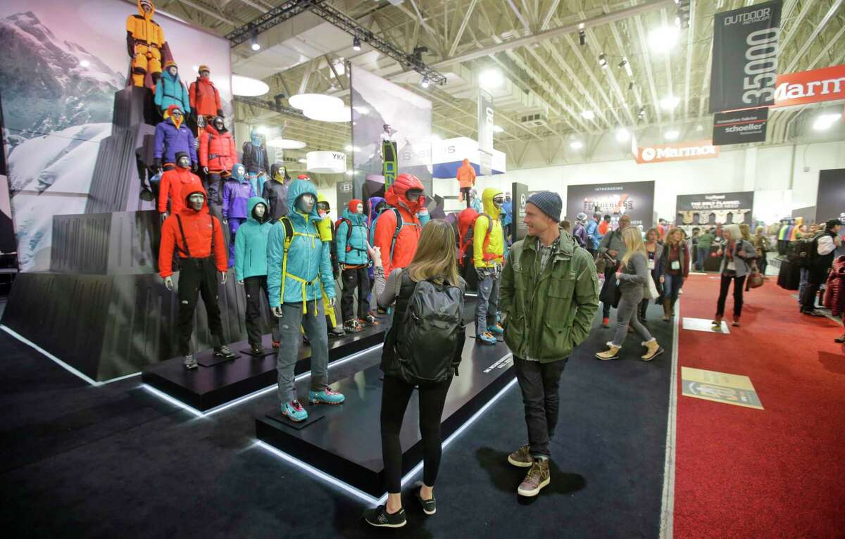 Attendees look over an exhibit at the Outdoor Retailer trade show at the Salt Palace Convention Center in Salt Lake City. The show is leaving Utah after two decades over state leaders' stance on public lands.