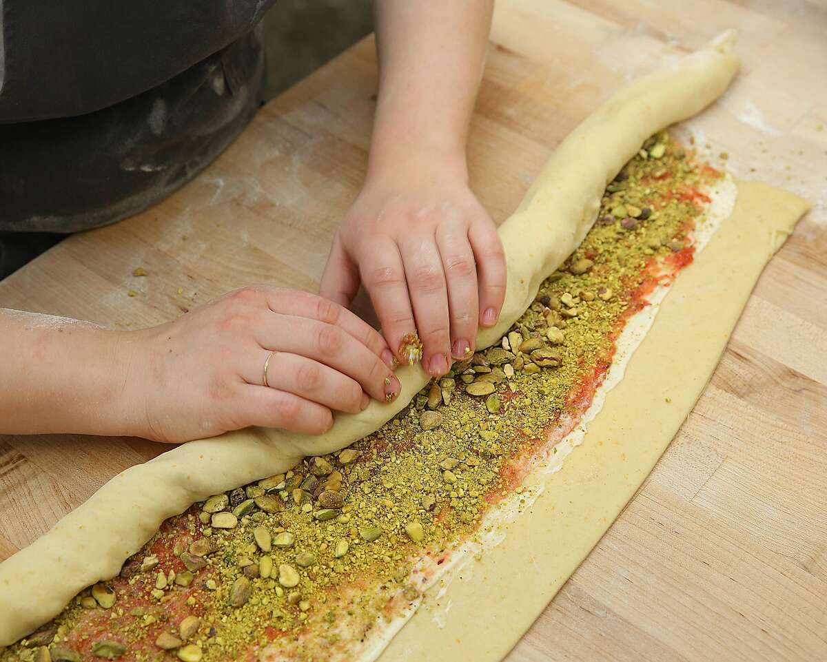 Partner and head baker Avery Ruzicka shows how to roll dough with ingredients to make King Cake at Manresa Bread on Thursday, February 16, 2017, in Los Gatos, Calif.