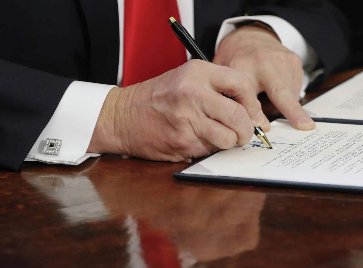 President Donald Trump signs an executive order in the Oval Office of the White House in Washington. It didn’t take long for President Donald Trump to start running out of the custom-made Cross pens he uses to sign all of his executive orders. “I think we’re going to need some more pens, by the way,” he said on Inauguration Day, after handing them out as souvenirs for lawmakers who attended his first signing ceremony.