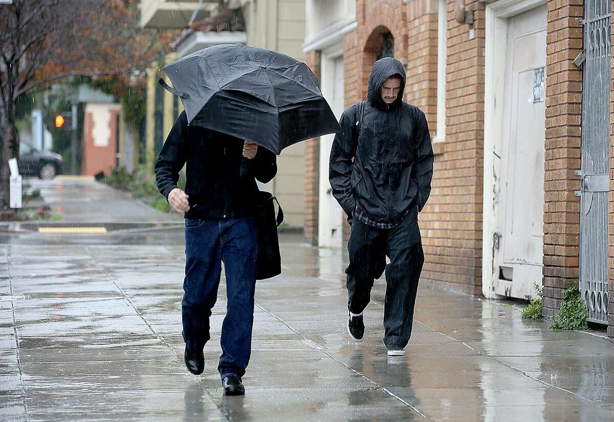 Pedestrians walk down 25th Street in the rain on Friday, February 18, 2017, in San Francisco, Calif.
