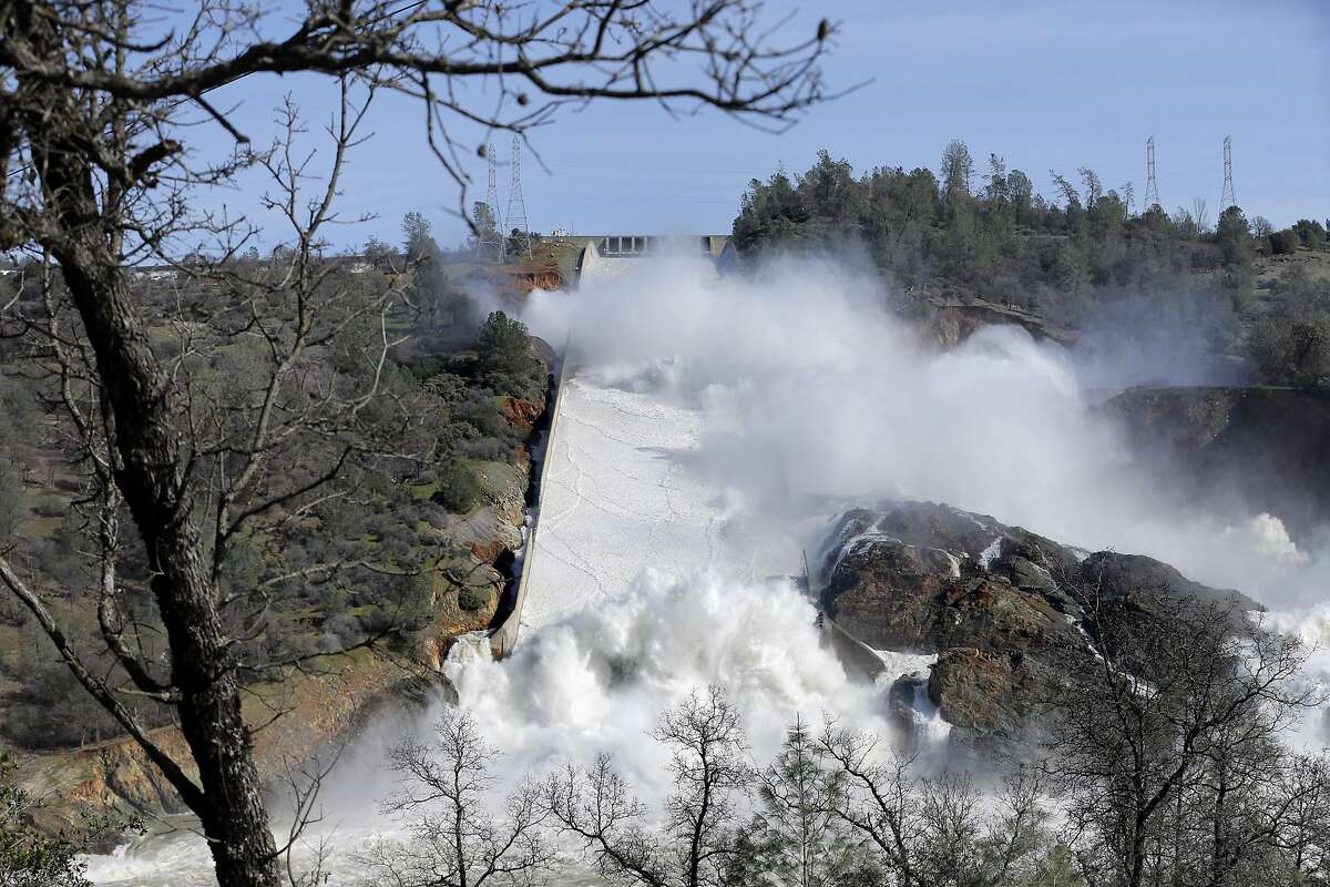 Thousands of gallons of water rush over the main and auxiliary spillway at Oroville Dam in Oroville, Calif., on Sunday, February 12, 2017. The California Department of Water Resources is now working to remove debris from the river so water flow down the Feather River doesn't impede the hydroelectric generation at the dam.