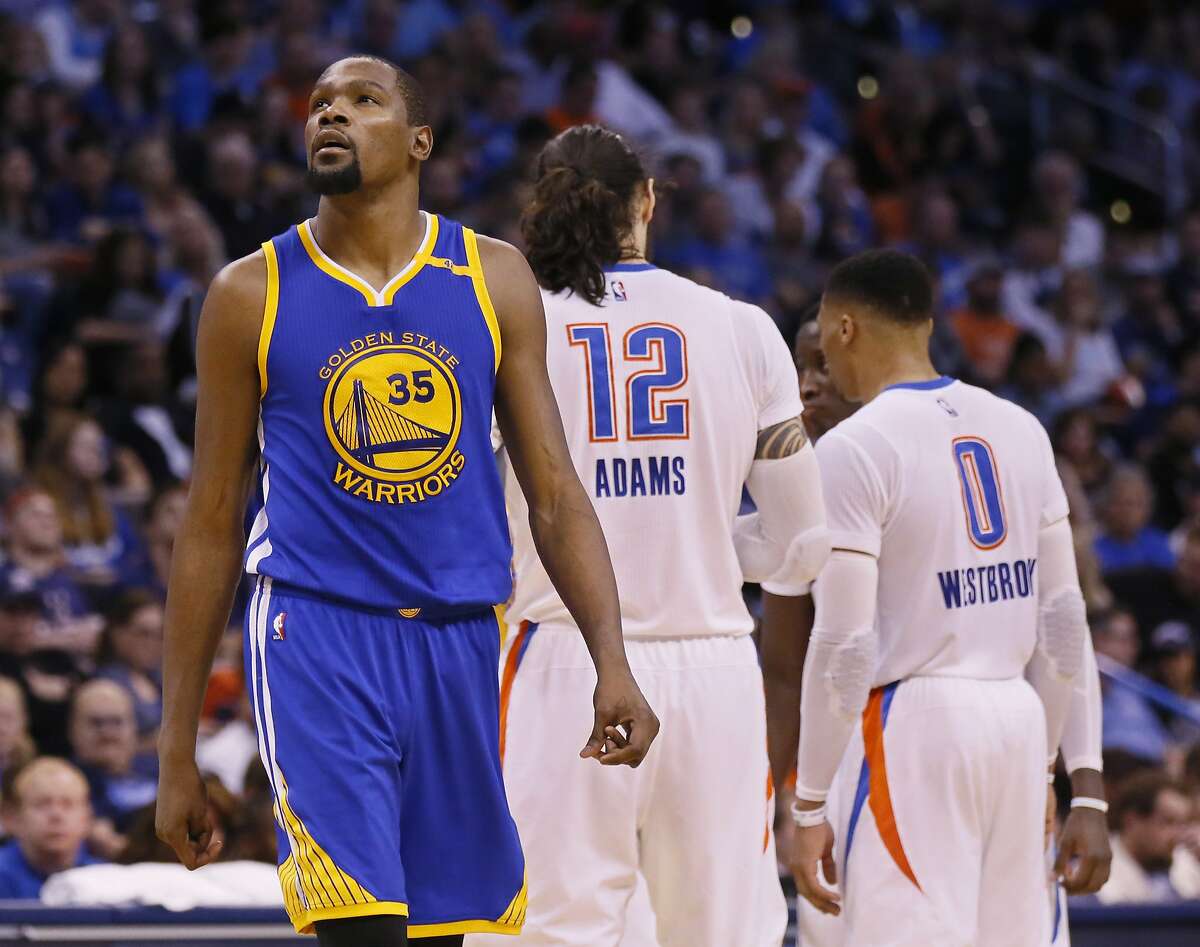 Golden State Warriors forward Kevin Durant (35) walks past former teammates Oklahoma City Thunder center Steven Adams (12) and guard Russell Westbrook (0) in the second quarter of an NBA basketball game in Oklahoma City, Saturday, Feb. 11, 2017. (AP Photo/Sue Ogrocki)