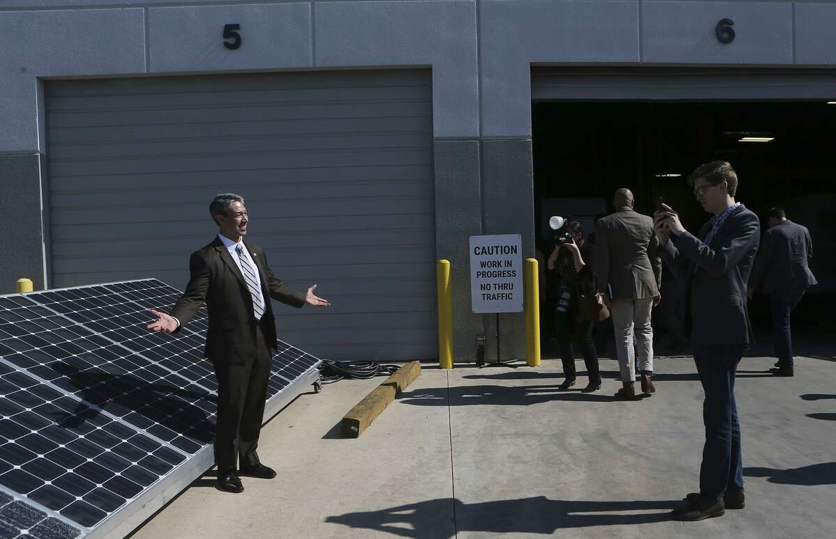 District 8 City Councilman Ron Nirenberg (left) poses for a picture by some solar panels during Friday’s tour of a manufacturer of solar power inverters, Kaco New Energy. Inverters take the DC power created by solar panels and convert it to AC power, which is the type that can be used by homes and businesses.
