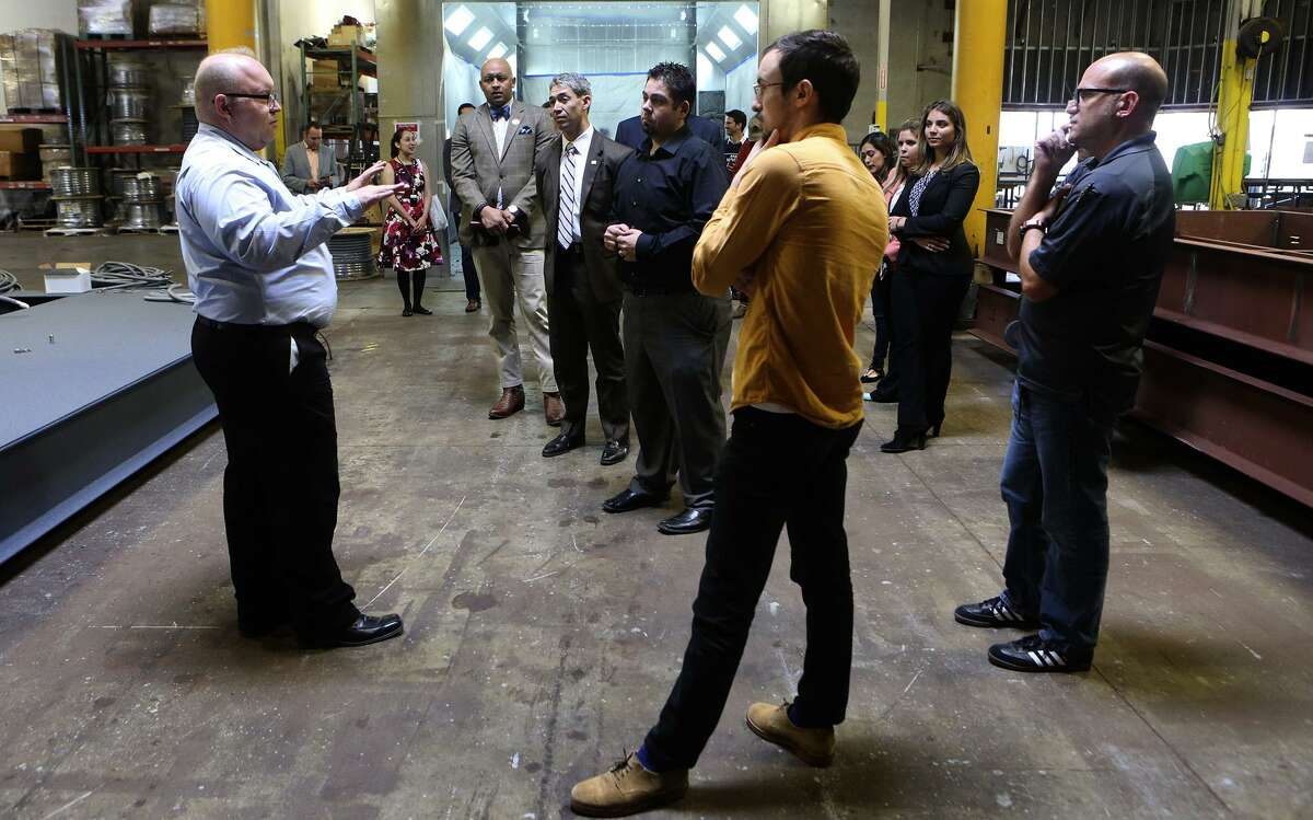 Bradley Feuge (left), head of project management for Kaco New Energy, leads a tour at the company’s manufacturing plant Friday.