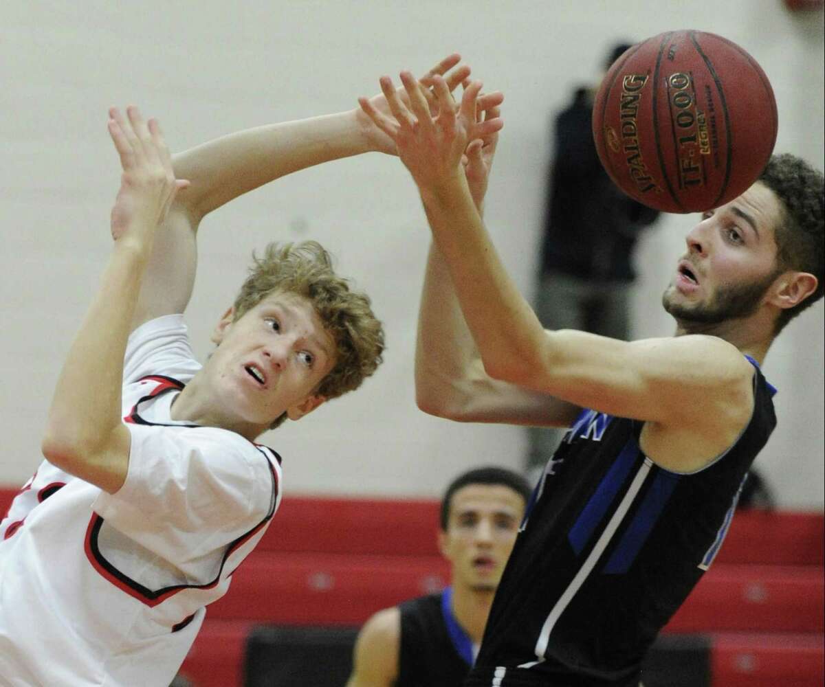 New Canaan’s Matthew Brand and Darien’s Alex Preston battle for a loose ball on Friday.