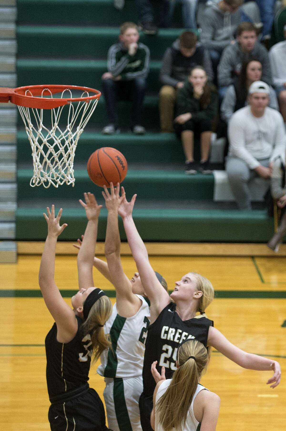 BRITTNEY LOHMILLER | blohmiller@mdn.net Bullock Creek's Mayson Barringer, left, and Haley Heldt work block Freeland's Mary Hemgesberg's lay-up in the second half of the Friday evening game at Freeland High School. Freeland defeated Bullock Creek 68-25 and remain undefeated.
