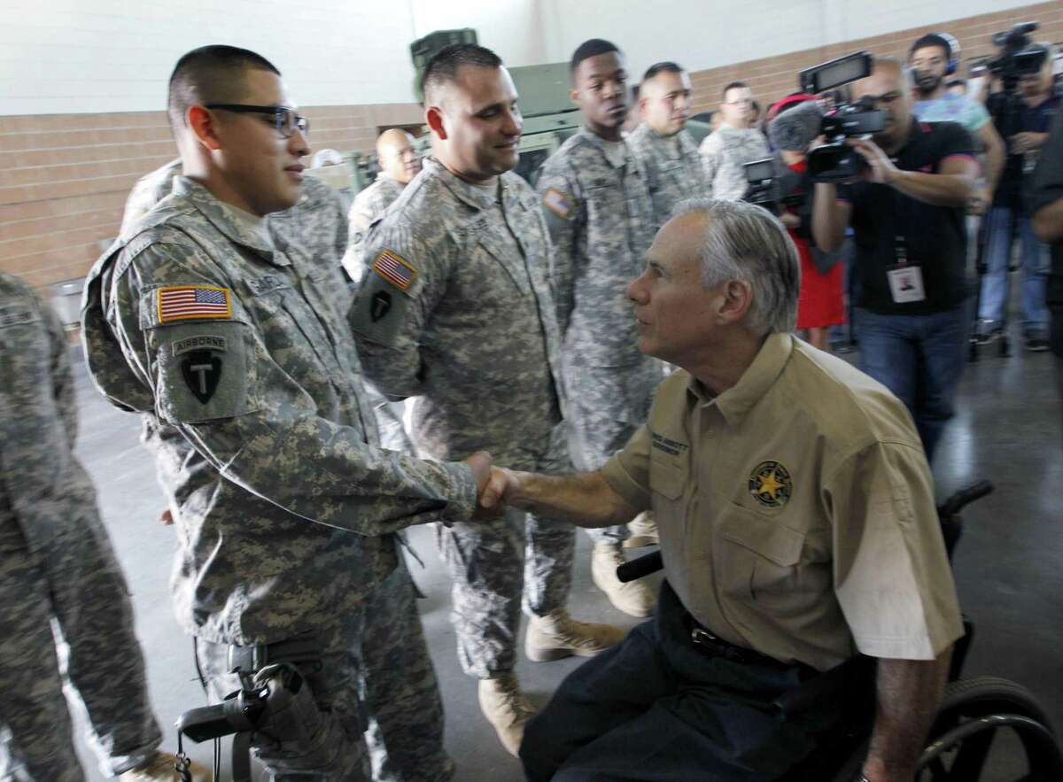 Texas Gov. Greg Abbott shakes Texas National Guard Spc. Jesus Garza after a briefing on their border security mission, Wednesday, Dec. 23, 2015 at the National Guard Armory in Weslaco, Texas. (Nathan Lambrecht/The Monitor via AP)