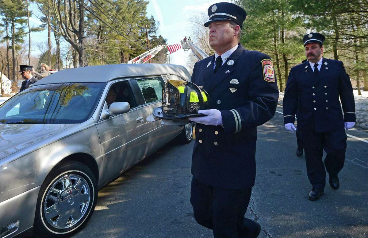 A Bridgeport firefighter carries a helmet in honor of Phil Reeves, a long time Wilton resident, U.S. Army veteran, and professional firefighter who served the Westport and Bridgeport communities, during a funeral procession Saturday, February 18, 2017, outside at St. Matthew?’s Church on New Canaan Road, in Wilton, Conn.