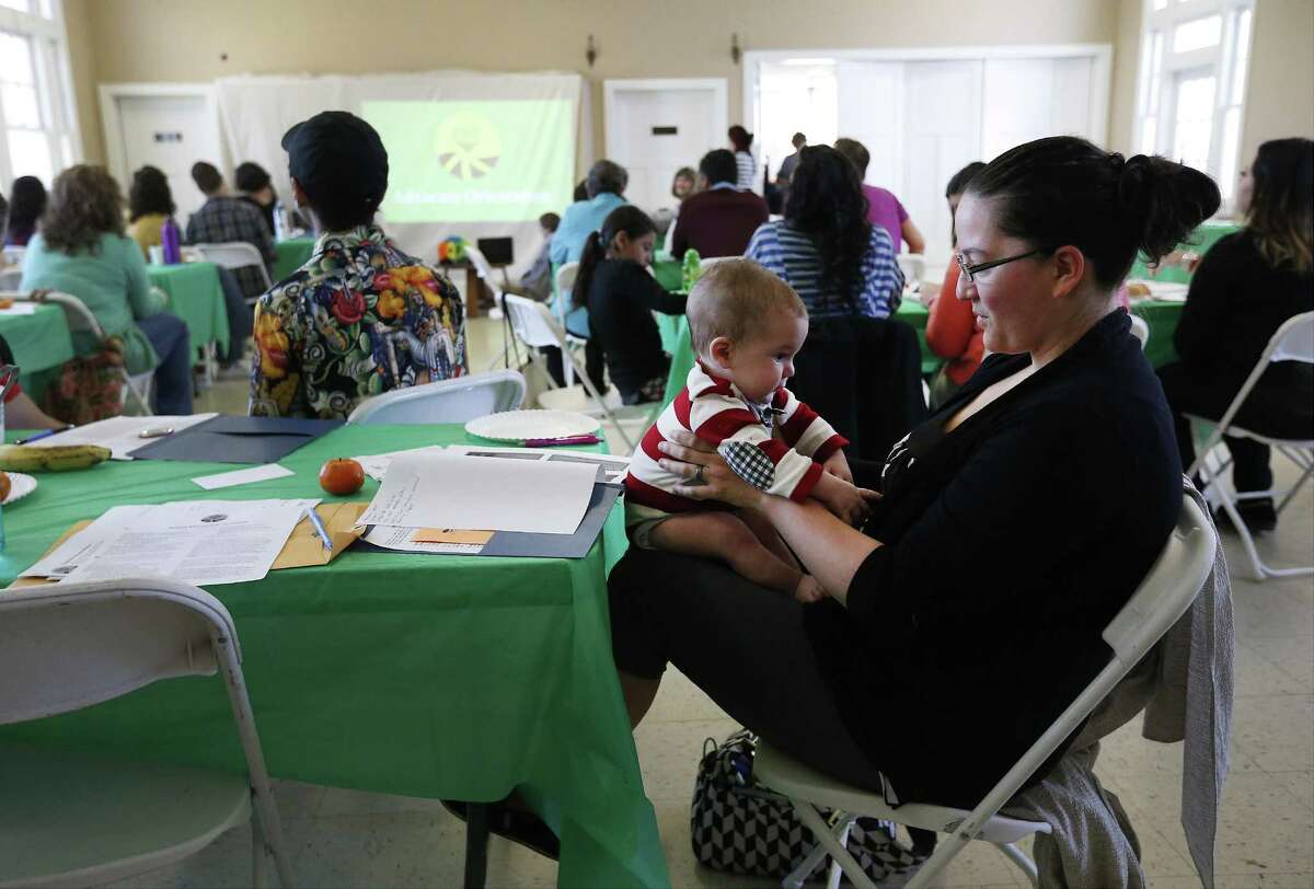 Lisa Richardson with her four-month old son attend a workshop hosted by Refugee and Immigrant Center for Education and Legal Services (RAICES) and their shelter program organization Casa de Raices for people interested in learning how to assist and advise refugees - especially women and their children - placed in family detention on Saturday, Feb. 18, 2017. (Kin Man Hui/San Antonio Express-News)