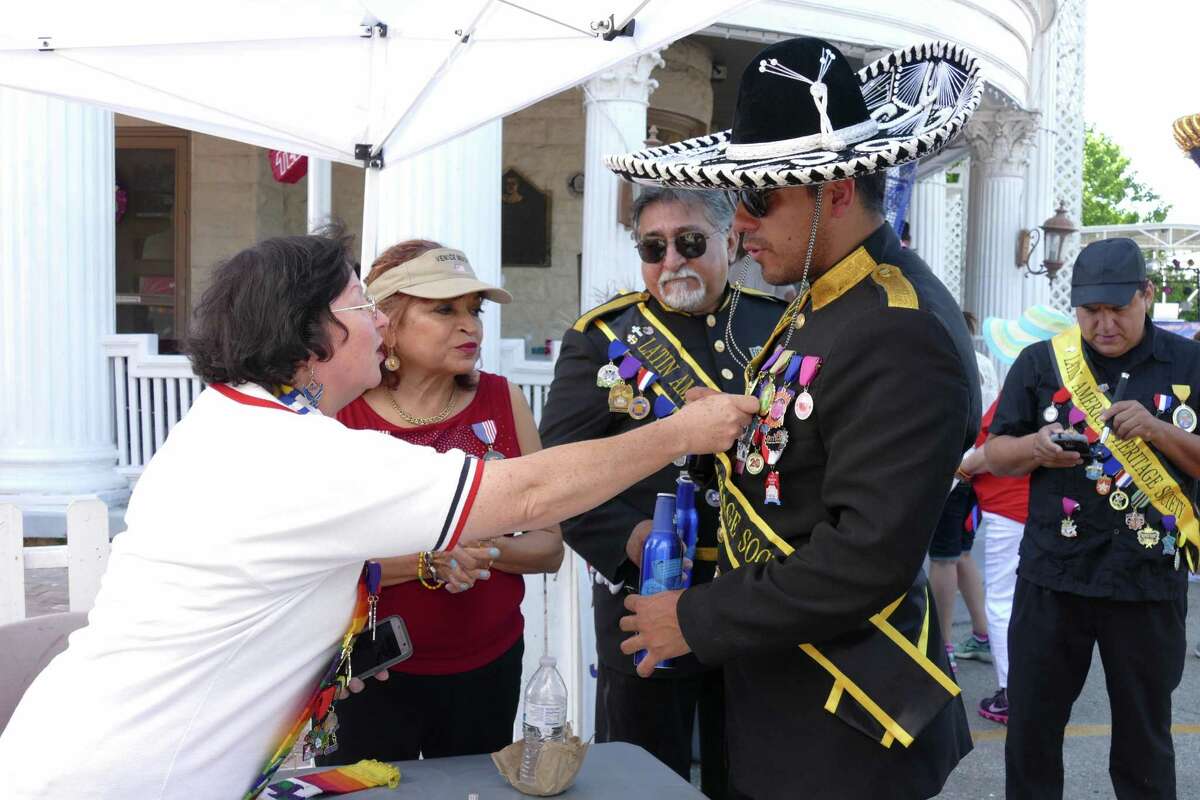 Karen Morgan, who is retired from the Air Force, inspects Fiesta medals on the chest of Latin American Heritage Society member Girien Salazar at VFW Post 76 during the 10th Street River Festival on Saturday, April 23, 2016. Proceeds from the event will help maintain the VFW's historic building and fund veteran programs.
