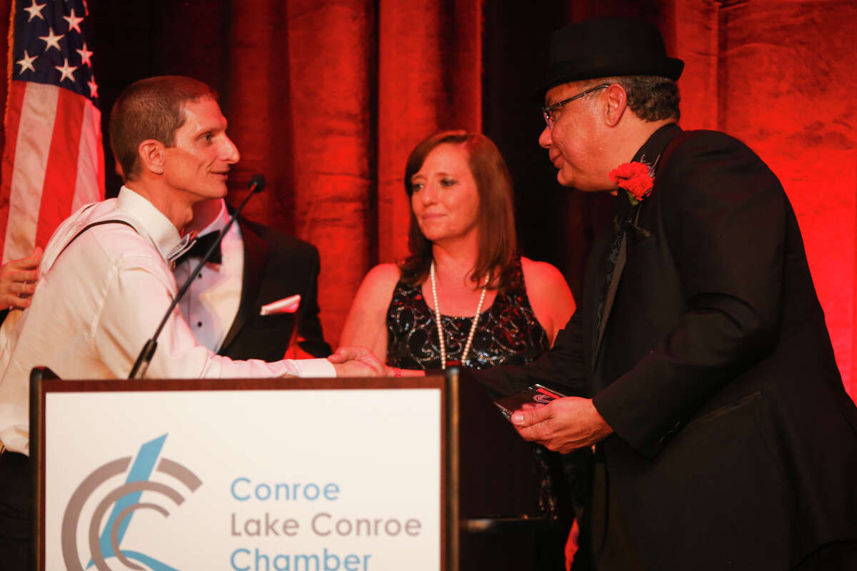 Outgoing board chairman Hector Forestier, of the Conroe/Greater Lake Conroe Chamber of Commerce, presents the Large Business of the Year award to Consolidated Communications during the Chairman's Ball on Saturday, Jan. 21, 2017, at La Torretta Lake Resort & Spa.
