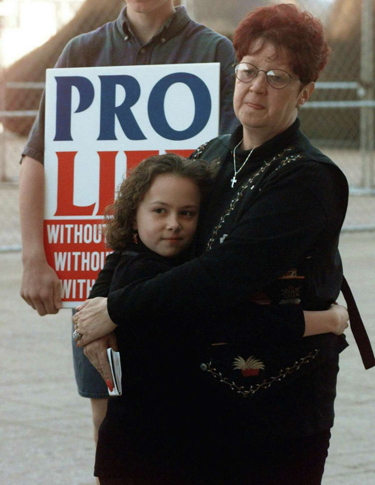FILE - In this Jan. 22, 1997, file photo, Norma McCorvey, right, known as Jane Roe in the landmark U.S. Supreme Court ruling 24 years ago that legalized abortion nationwide, stands with her friend Meredith Champion, 9, at an Operation Rescue rally in downtown Dallas. Norma McCorvey, the "Jane Roe" at the center of the 1973 U.S. Supreme Court decision that legalized abortion, has died. She was 69. Journalist Joshua Prager, who is working on a book about McCorvey, says she died Saturday, Feb. 18, 2017, morning at an assisted living centre in Katy, Texas. Although McCorvey was the plaintiff in Roe v. Wade, she later became an anti-abortion activist. (AP Photo/Ron Heflin, File)