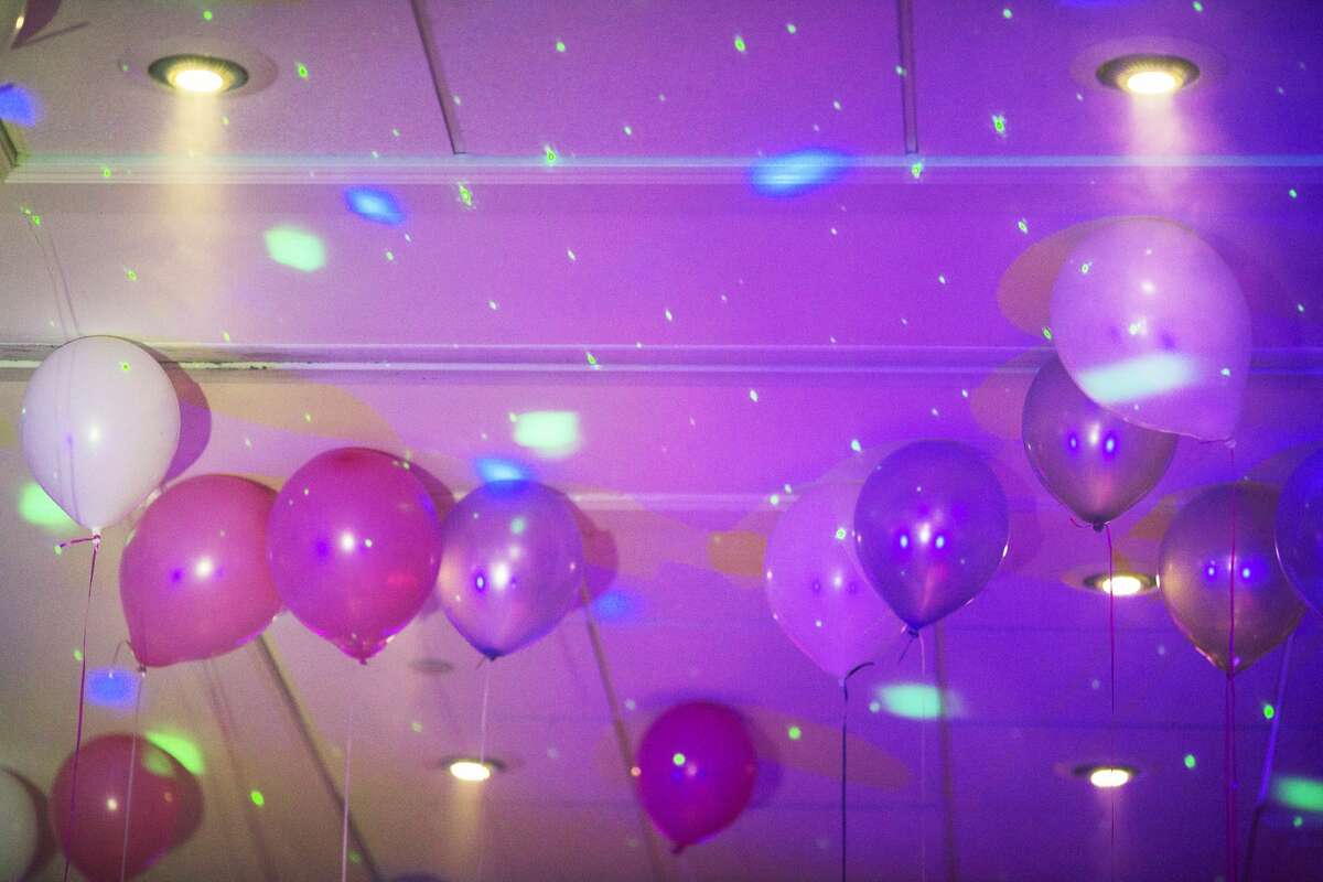 Balloons cling to the ceiling while being hit by strobe lights during the Midland Mom Prom at the Great Hall Banquet and Convention Center on Saturday.
