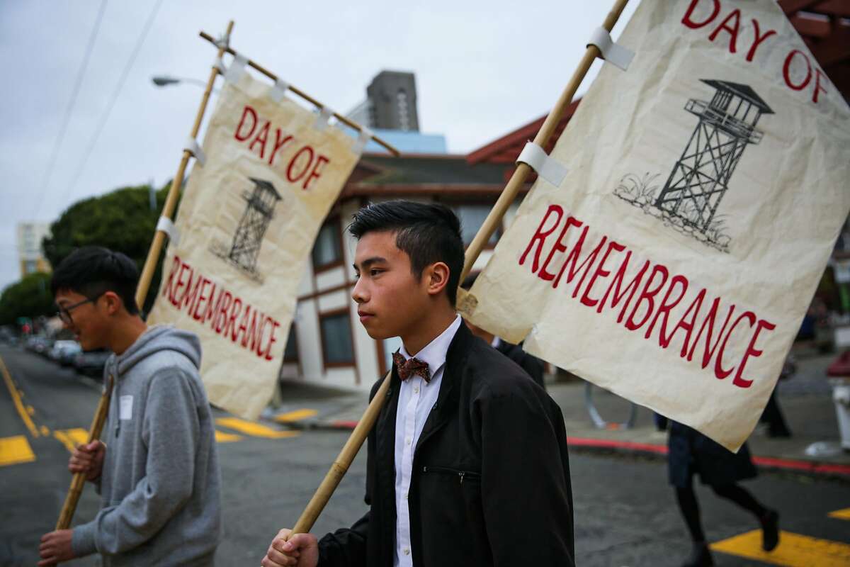 Aaron Huang (left) and Wesley Wong (right) carry banners during a procession from the Kabuki Cinema to the Japanese Cultural Center during the Remembrance of the 75th anniversary of executive order 9066 in San Francisco, California, on Sunday, Feb. 19, 2017.