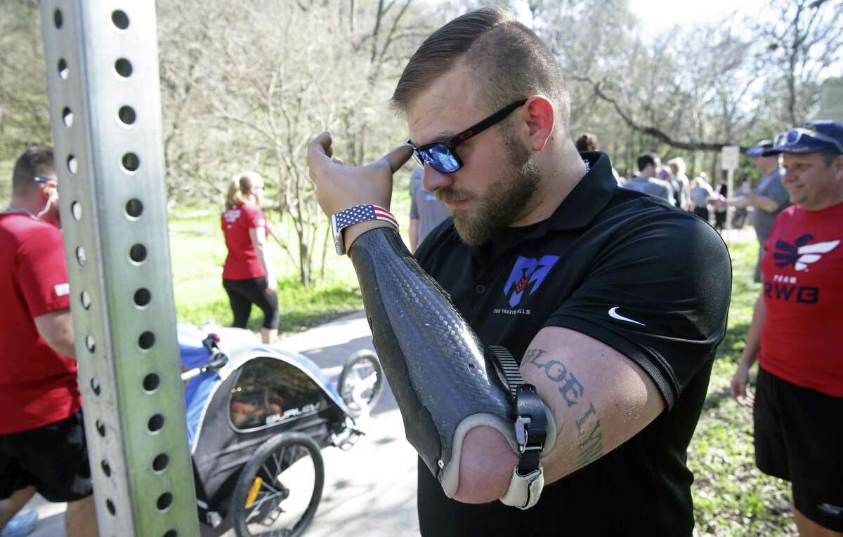 Adjusting his sunglassed with his prosthetic armafter runners get going, Travis Mills, a quadruple amputee Army veteran serves as the honorary starter for the Be Great by Choice 5K run at Lady Bird Johnson Park on February 17, 2017.