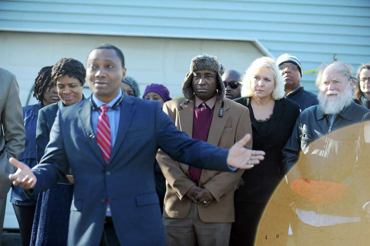 Victims Heather Lindsay and her common-law husband Lexene Charles listen to lawyer Andre Cayo during a press conference in front of the High Clear Dr. home where a racial slur was painted on the garage in Stamford, Conn. on Monday, Feb. 20, 2017.