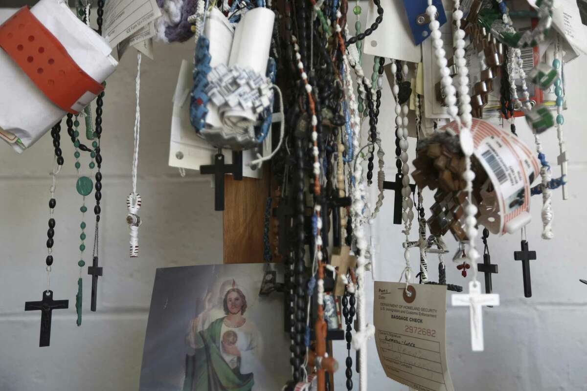 Dozens of migrant detention center bracelets and rosaries hang from a cross inside a migrant shelter in Ciudad Juarez.