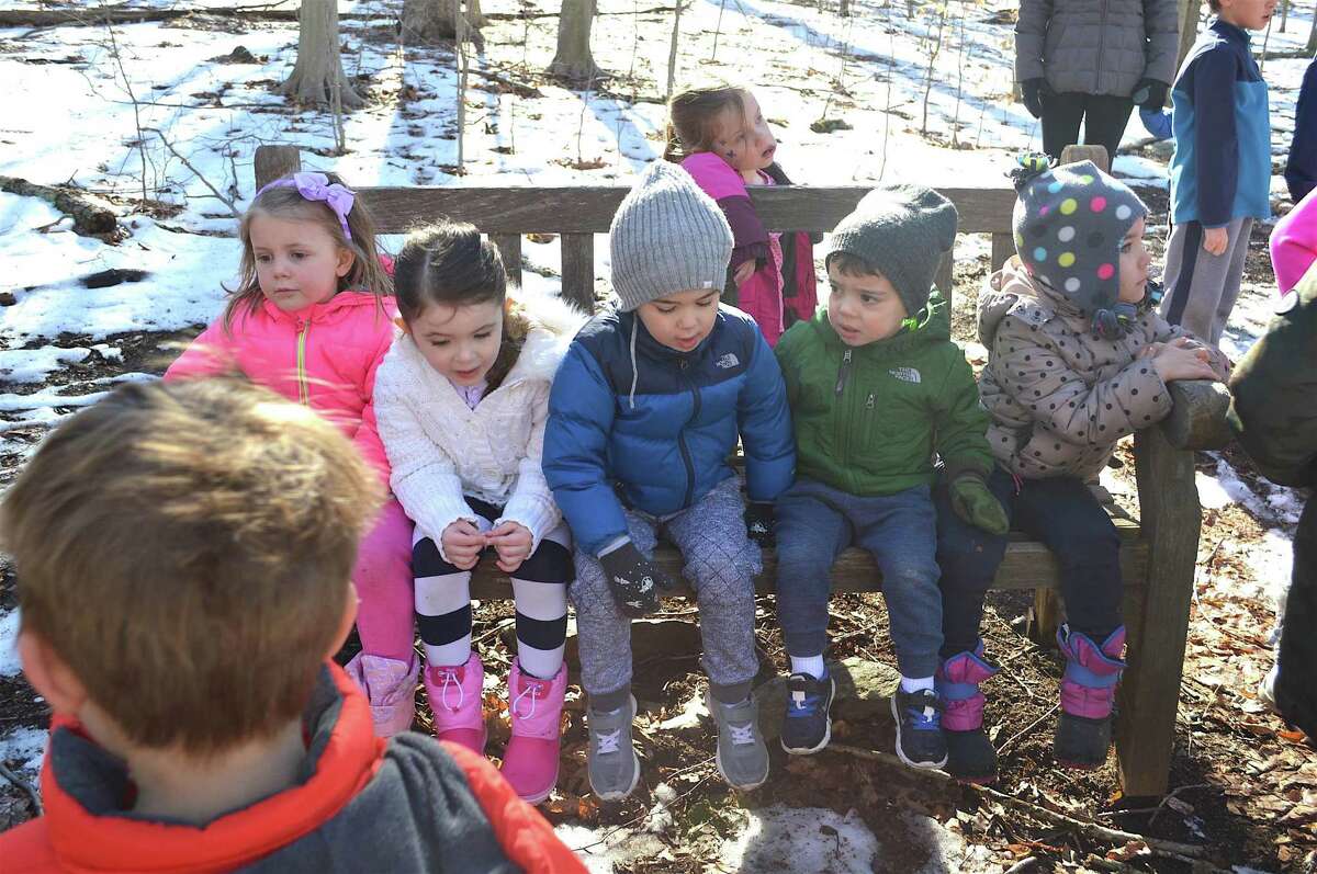 Kids take a bench break on the trail hike at the Earthplace Vacation Drop-Off Program, Monday, Feb. 20, 2017, in Westport, Conn.
