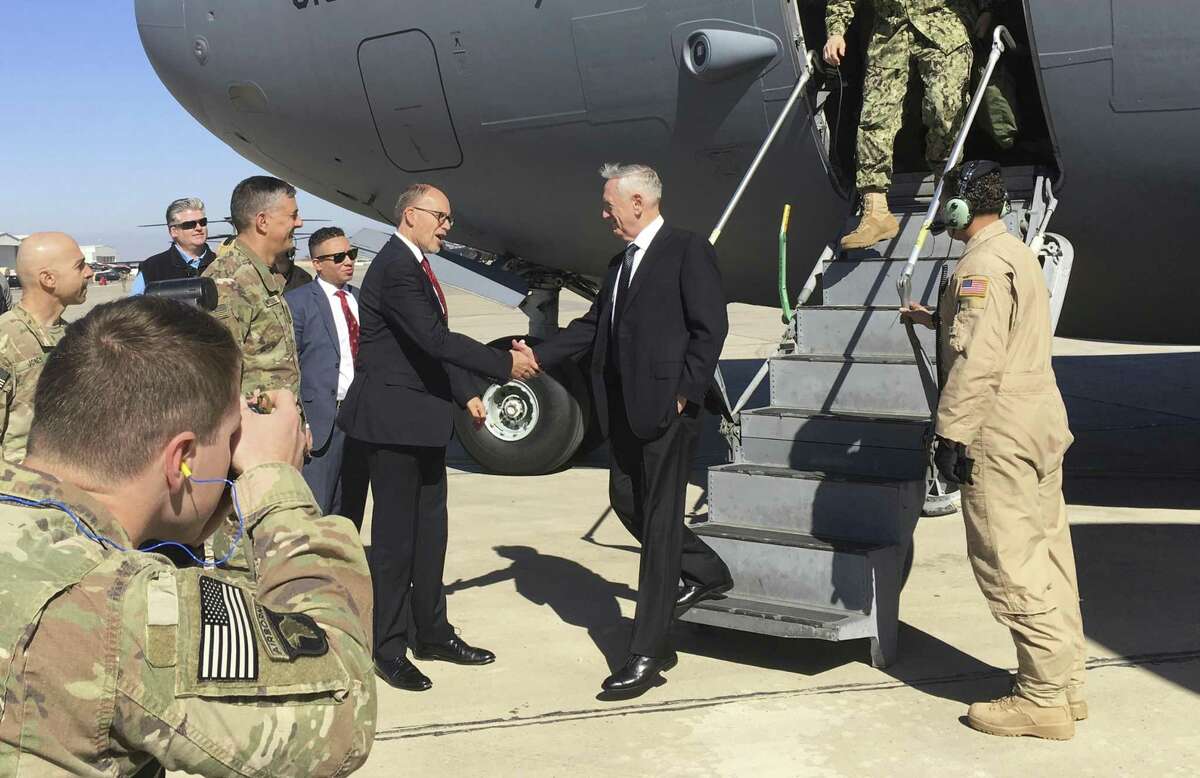 U.S. Secretary of Defense Jim Mattis, center, is greeted by U.S. Ambassador Douglas Silliman as he arrives at Baghdad International Airport on an unannounced trip Monday, Feb. 20, 2017. Mattis said Monday the United States does not intend to seize Iraqi oil, shifting away from an idea proposed by President Donald Trump that has rattled Iraq's leaders. (AP Photo/Lolita Baldor)