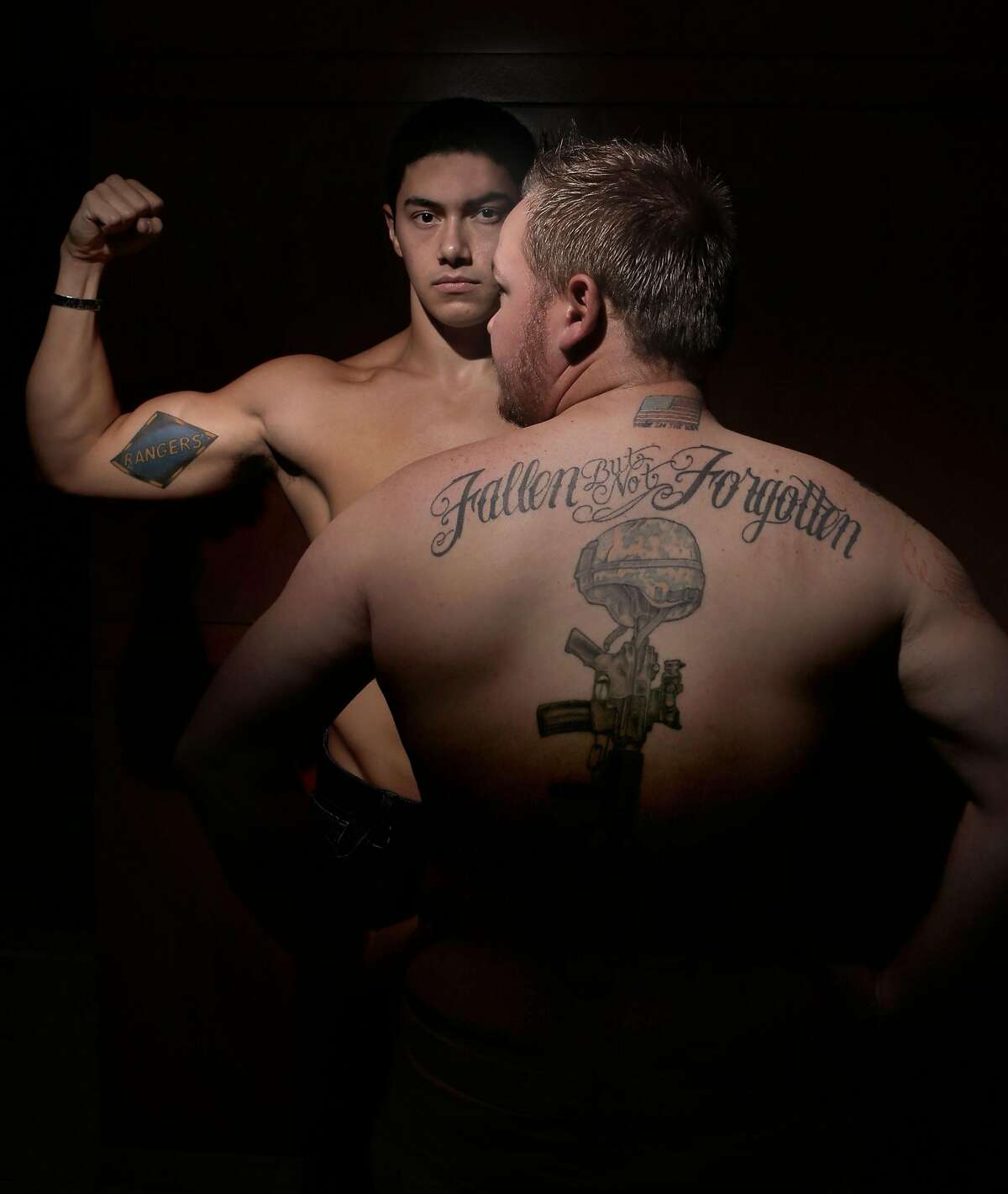 William Glazier, (left) of Gilroy, who served with the 1st Ranger Battalion of the US Army and Jonathan Snyder, of Des Moine, Iowa, who served with the US Army 4th Engineer Battalion display their tattoos, as seen on Friday Nov. 7, 2014 in Oakland, Calif. Veterans of the Iraq and Afghanistan wars come together to display their tattoos for an exhibition called War Ink.
