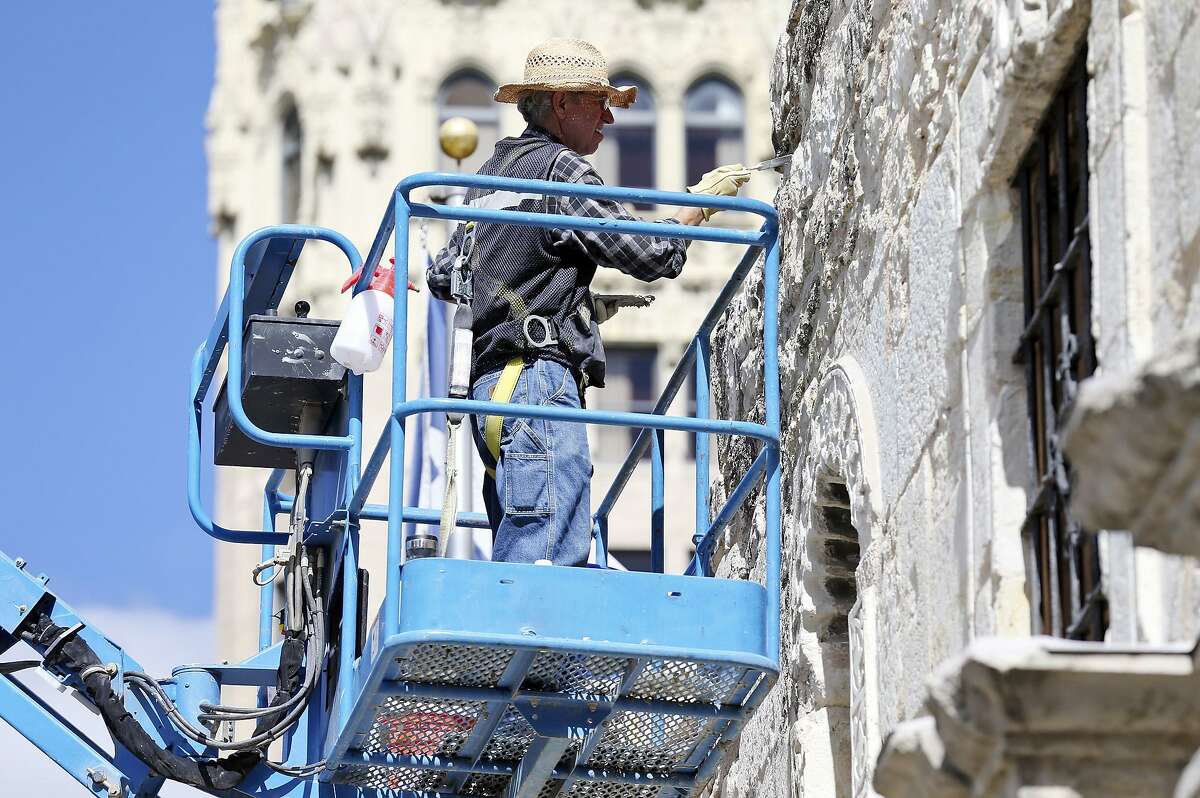 Preservation stone mason Miroslav Maler uses a lift to work on the facade of the Alamo Monday Oct. 26, 2015.